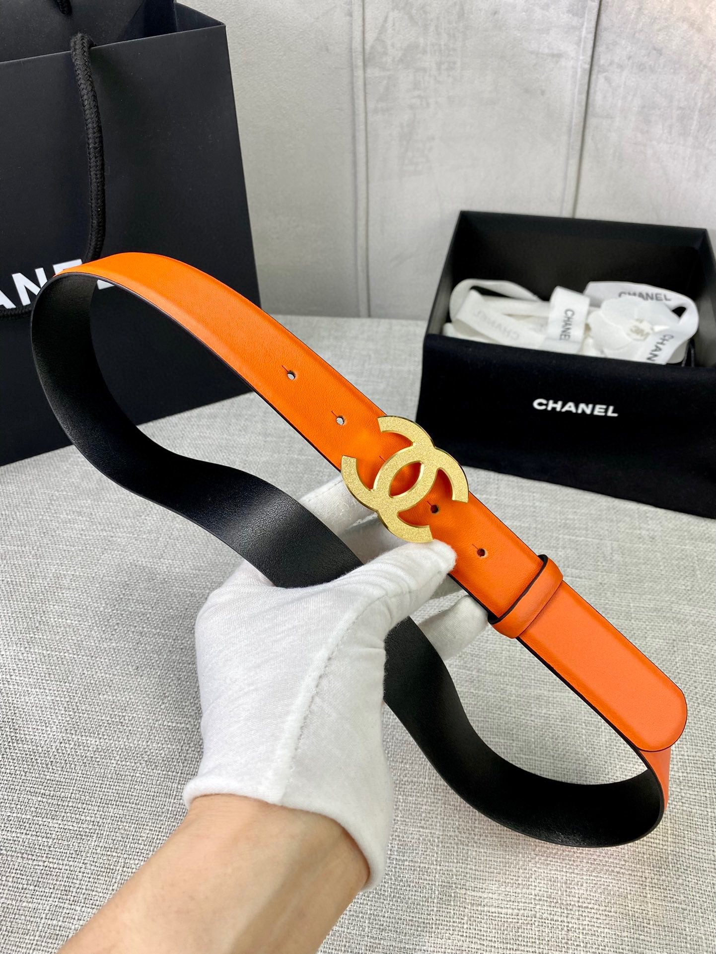 Chanel orange leather belt with gold CC buckle and black underside