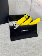 Chanel belt in bright yellow with gold CC logo buckle, resting in black pouch