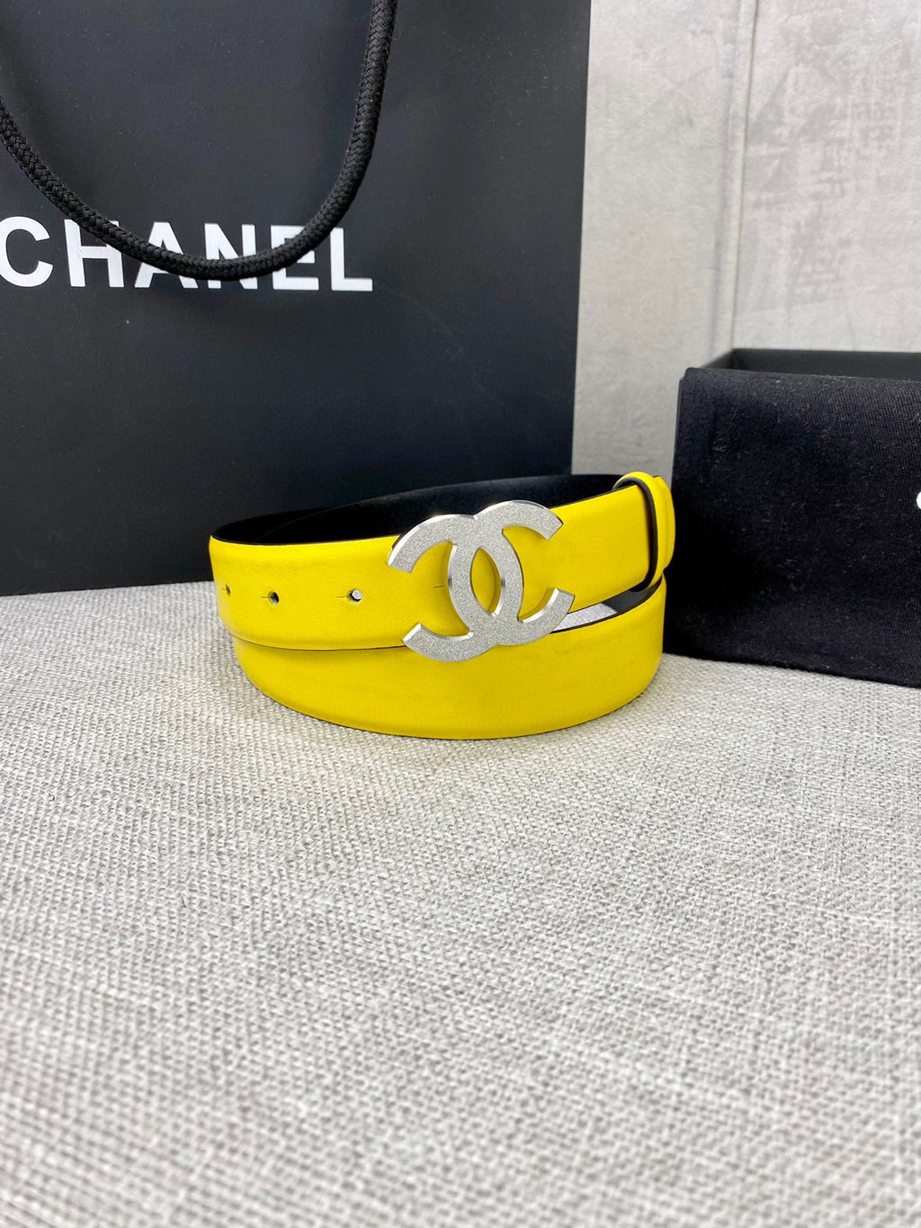 Chanel belt with bright yellow strap and large gold-tone CC clasp, angled