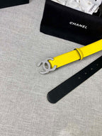Chanel belt close-up: bright yellow strap with gold CC logo and punched holes