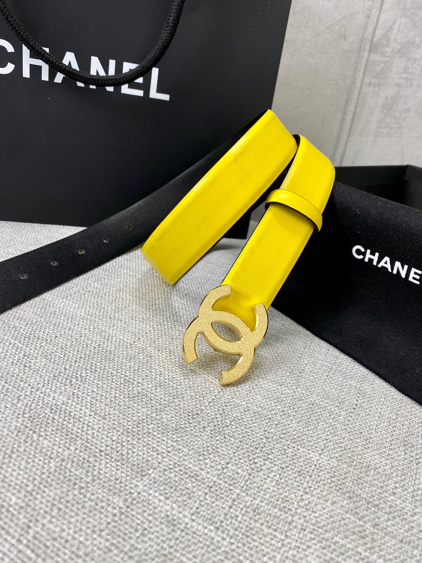 Chanel belt with bright yellow strap and gold CC buckle, coiled on display