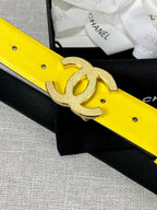 Chanel belt close-up: bright yellow leather with gold glitter CC logo buckle