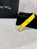 Chanel belt in bright yellow leather with gold CC buckle, beside black gift box