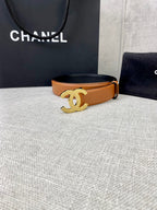Tan leather belt with gold-tone CC buckle, on tabletop display.
