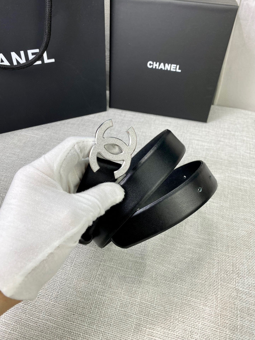 Chanel belt detail with silver-tone CC buckle and black leather strap