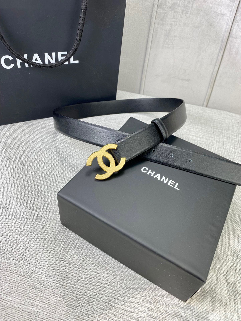 Chanel belt with gold-tone CC buckle on black leather strap, on box