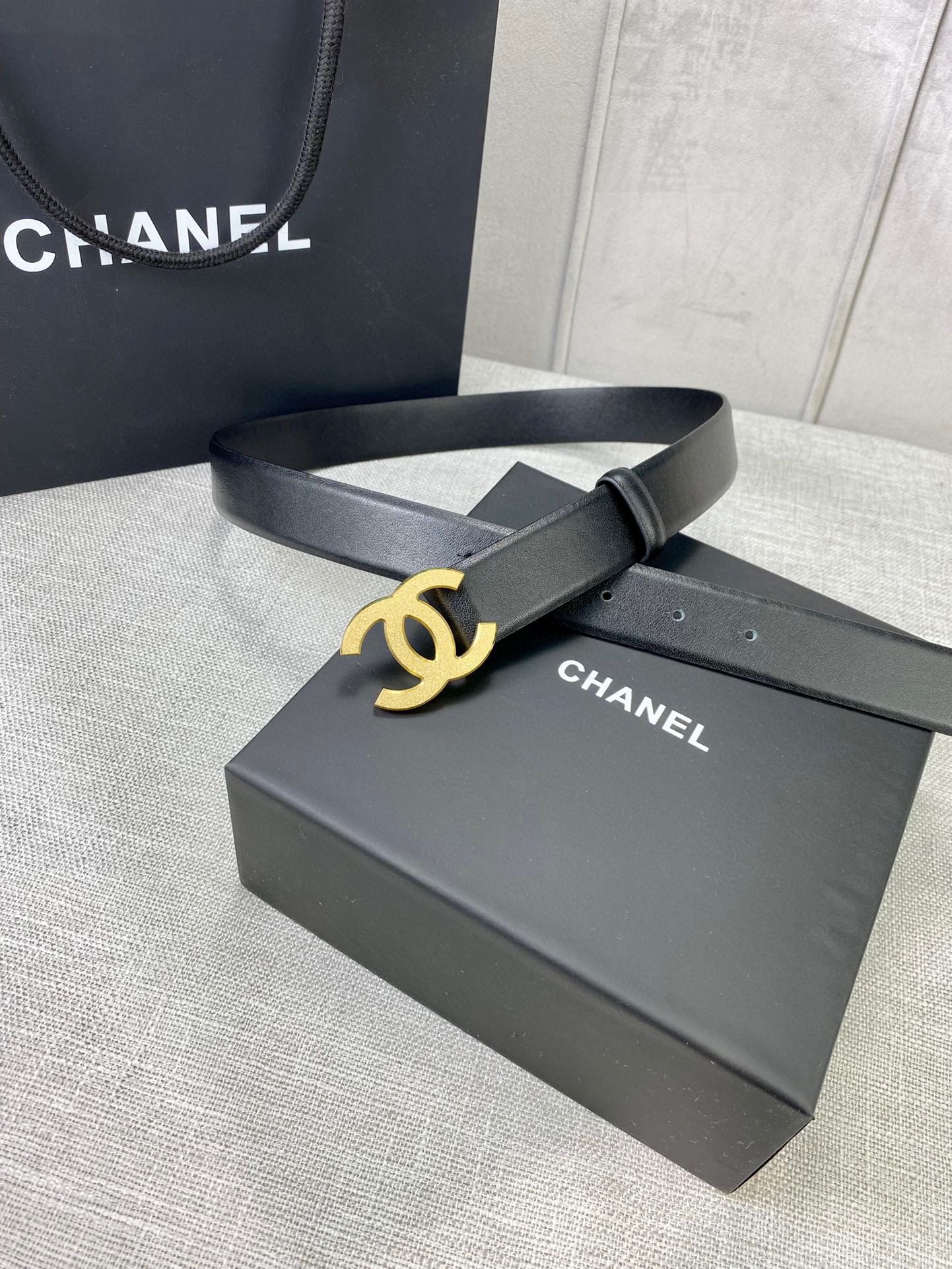 Chanel belt with gold-tone CC buckle on black leather strap, on box