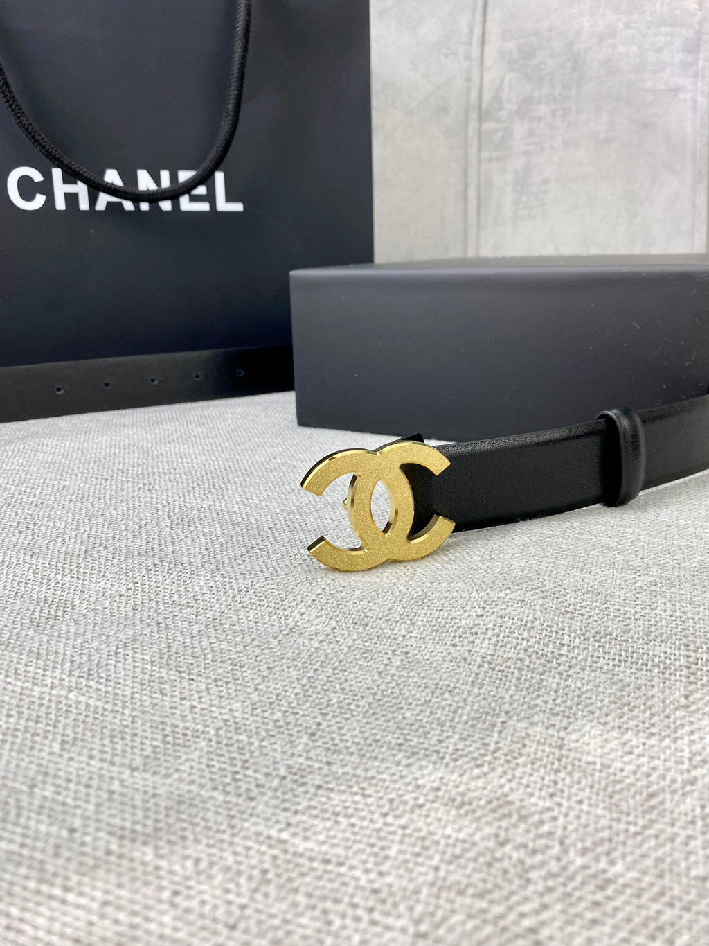 Chanel belt with black leather strap and gold-tone CC logo buckle, close up