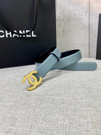 Chanel belt with light blue leather strap and gold logo buckle, side angle view.