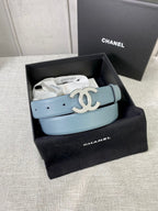 Chanel belt displayed in a gift box, light blue strap with metallic logo buckle.