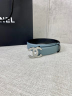 Chanel belt with light blue leather strap and metallic logo buckle, laid flat.