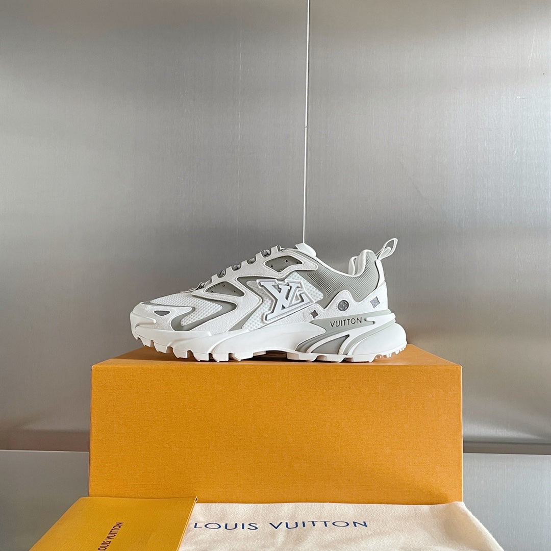 White and gray lace-up sneaker on top of a tan shoebox, chunky rubber sole