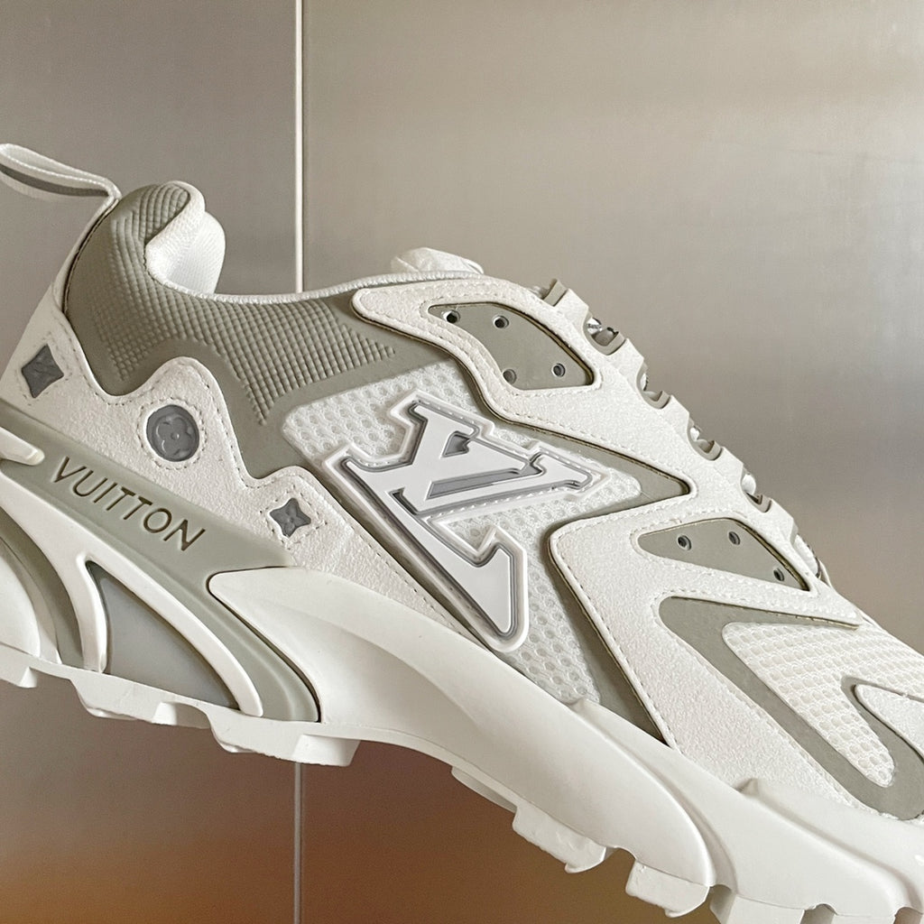 Close-up of a white and gray lace-up sneaker with molded logo overlays