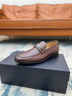 Tan-brown leather loafer with silver buckle strap, low heel, on presentation box
