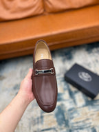 Brown Prada leather loafer with silver buckle strap, front view, held up