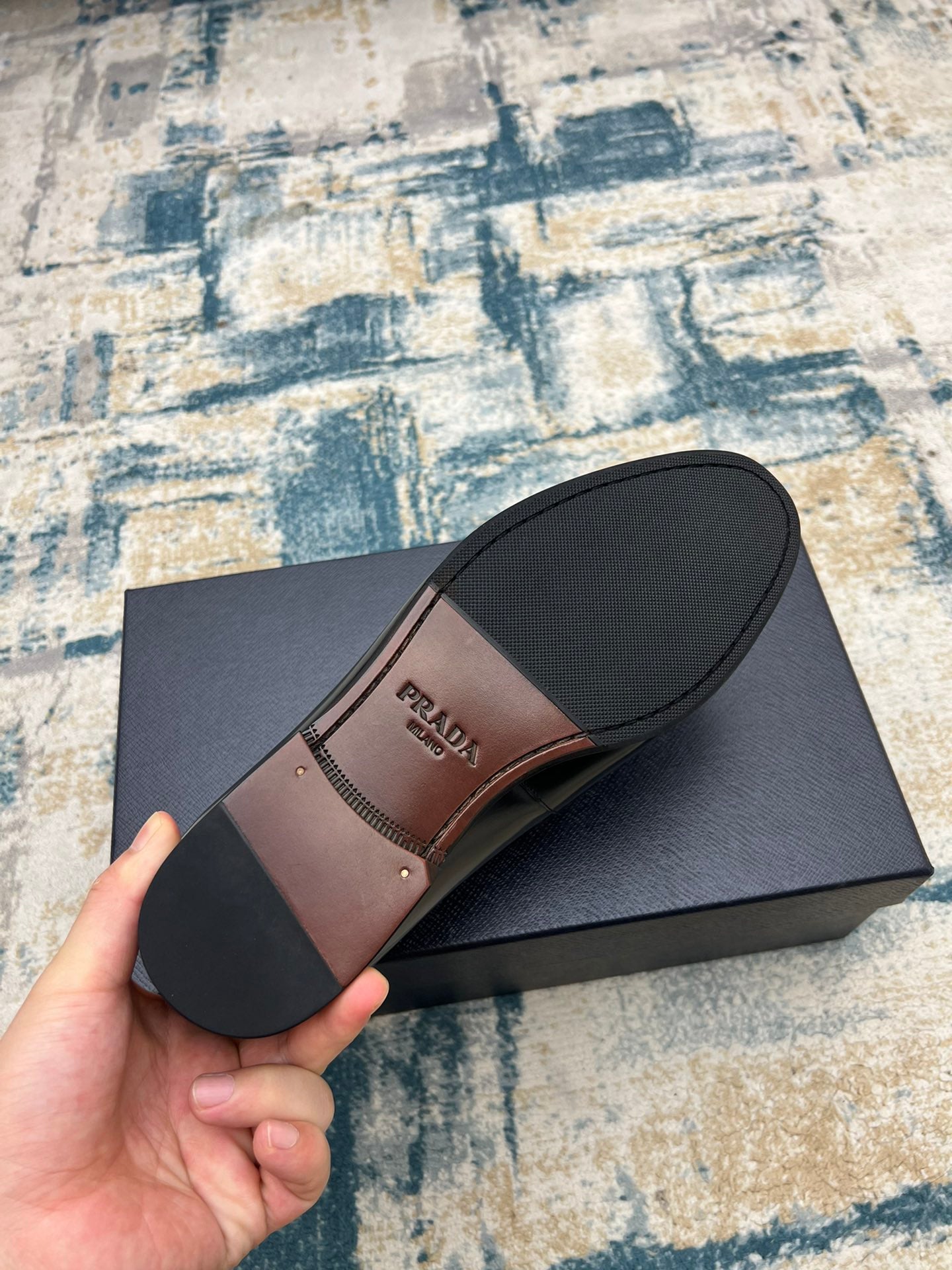 Prada black loafer shoe with buckle strap, view of sole and heel