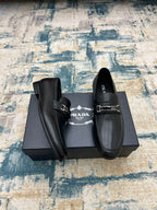 Prada unisex loafers with buckle strap and lining, black slip-on style.