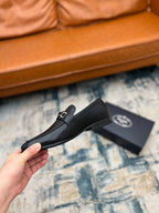 Prada unisex loafers, black leather with silver buckle strap, side angle on box.