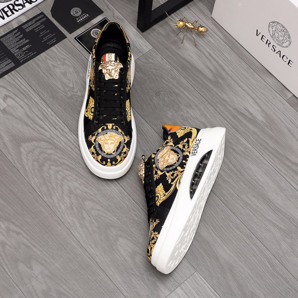 Pair of black low-top sneakers with gold baroque print and colorful heel detail, white soles.
