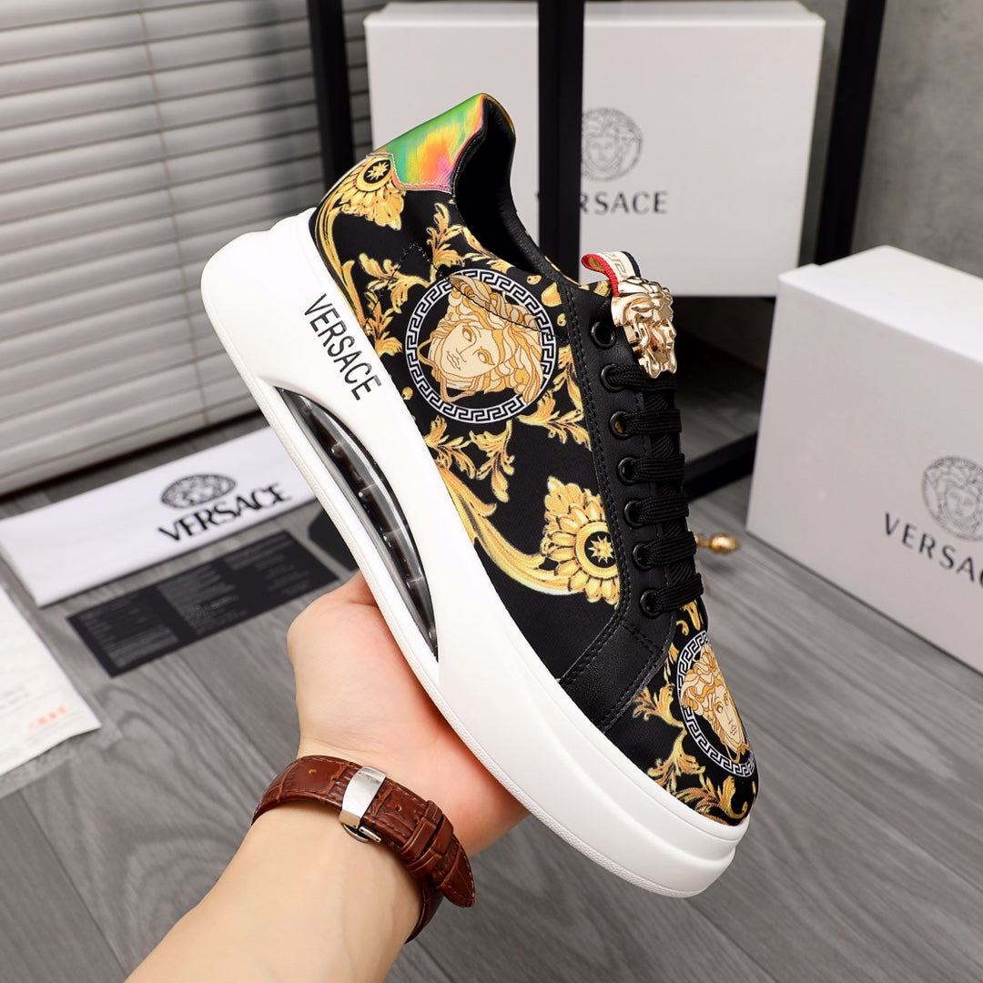 Black sneakers with gold baroque print and rainbow heel panel, lace-up front.