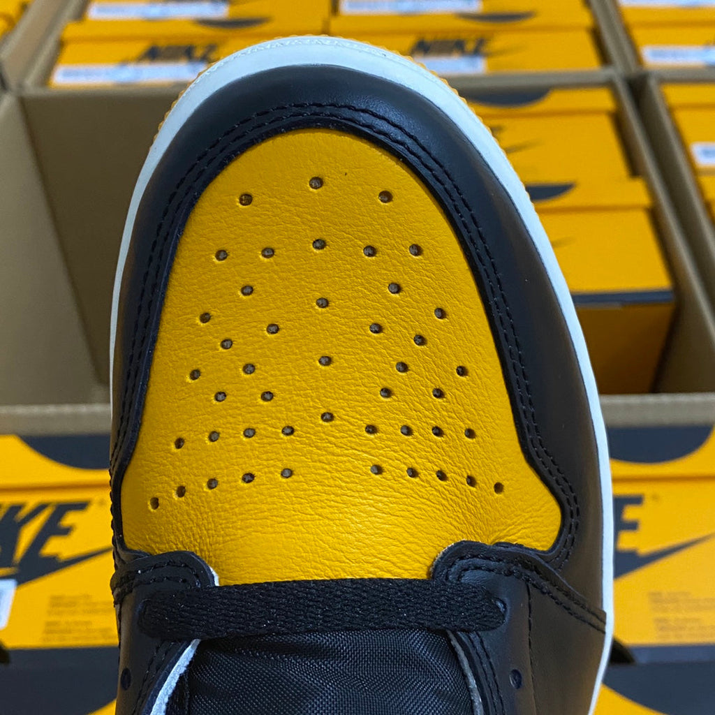 High-top sneaker toe box with yellow perforated leather and dark blue overlay