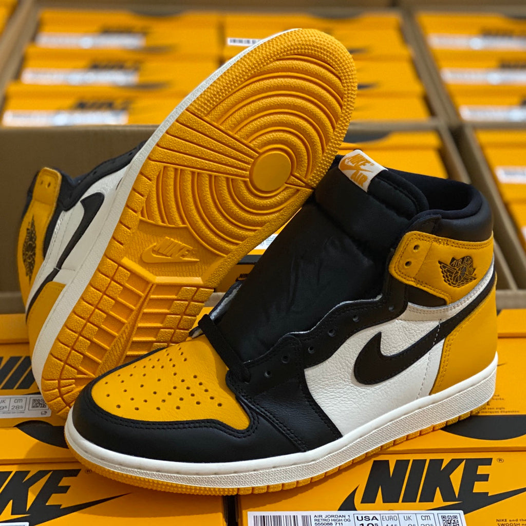 High-top sneaker angled with yellow outsole tread, yellow toe panel, black and white upper