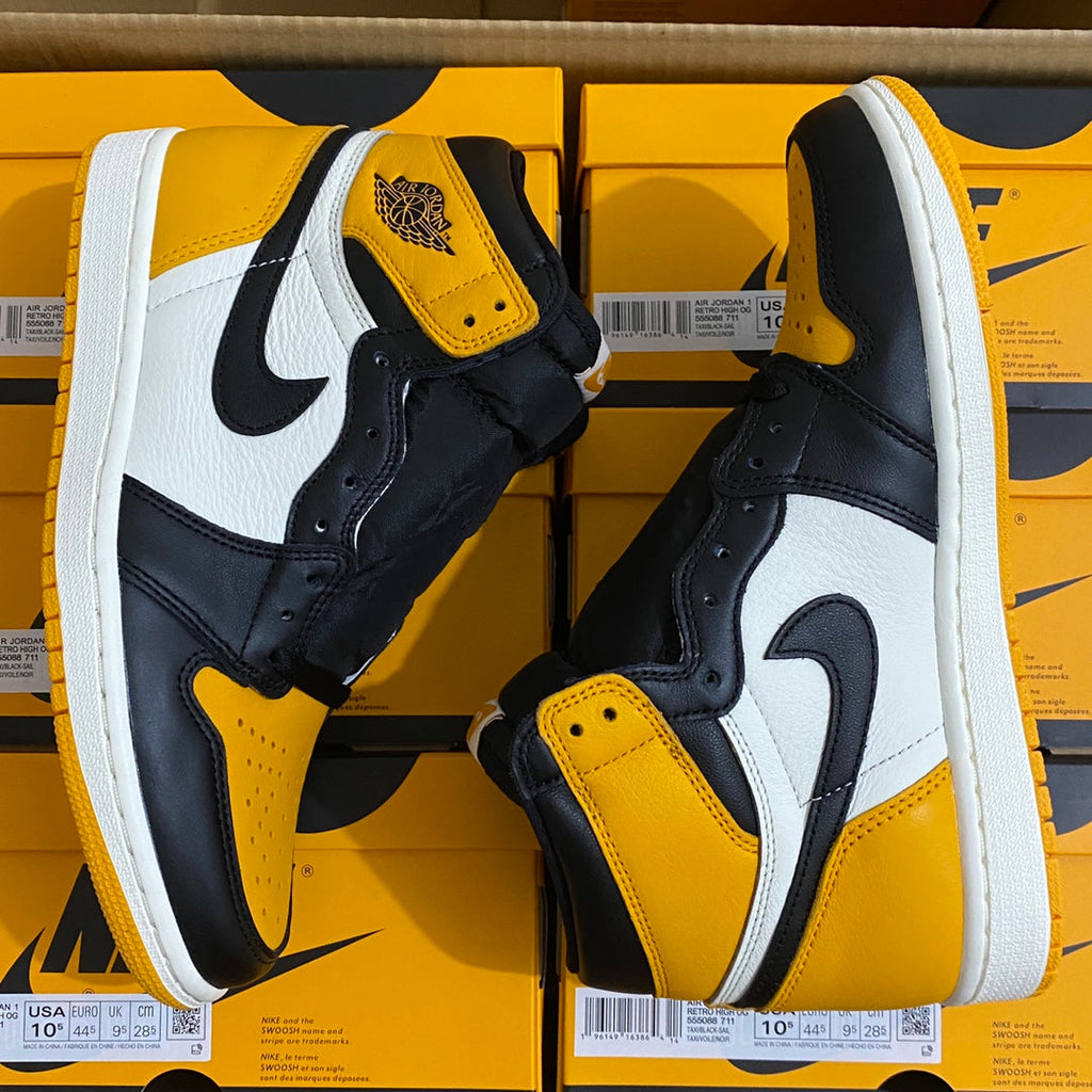 Pair of high-top sneakers front sides with yellow toe and ankle, white swoosh details