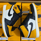 Pair of high-top sneakers front sides with yellow toe and ankle, white swoosh details