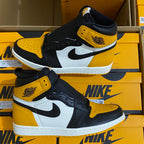 Pair of high-top sneakers with yellow and black panels, white midsole, black swoosh