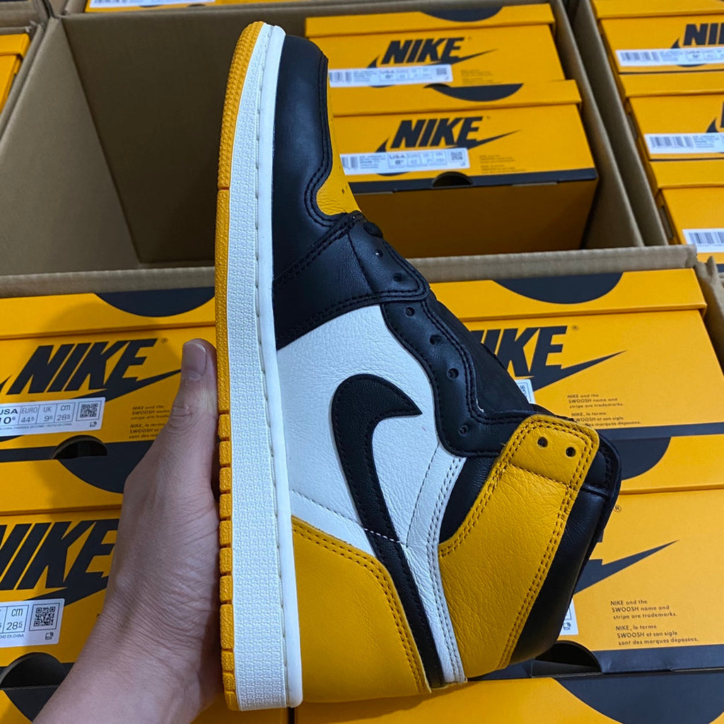 High-top sneaker side view with yellow toe panel, dark blue upper, white swoosh