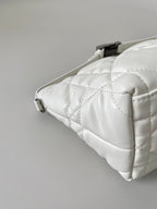 Quilted white Dior bag corner detail with top zipper and stitched panels