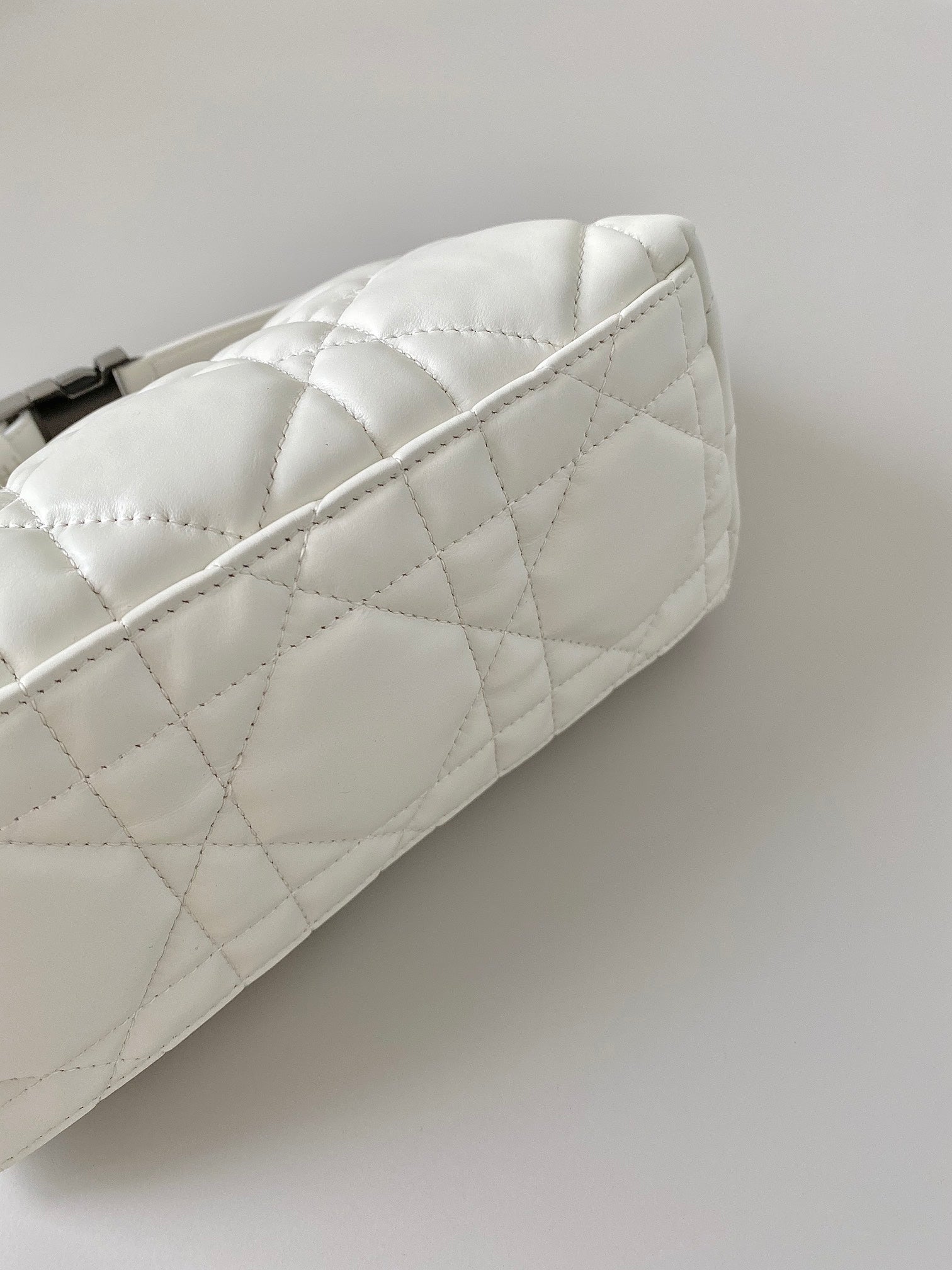 Quilted white Dior bag side profile with diamond stitching