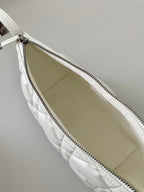 White quilted bag interior view showing open top and zipper track.