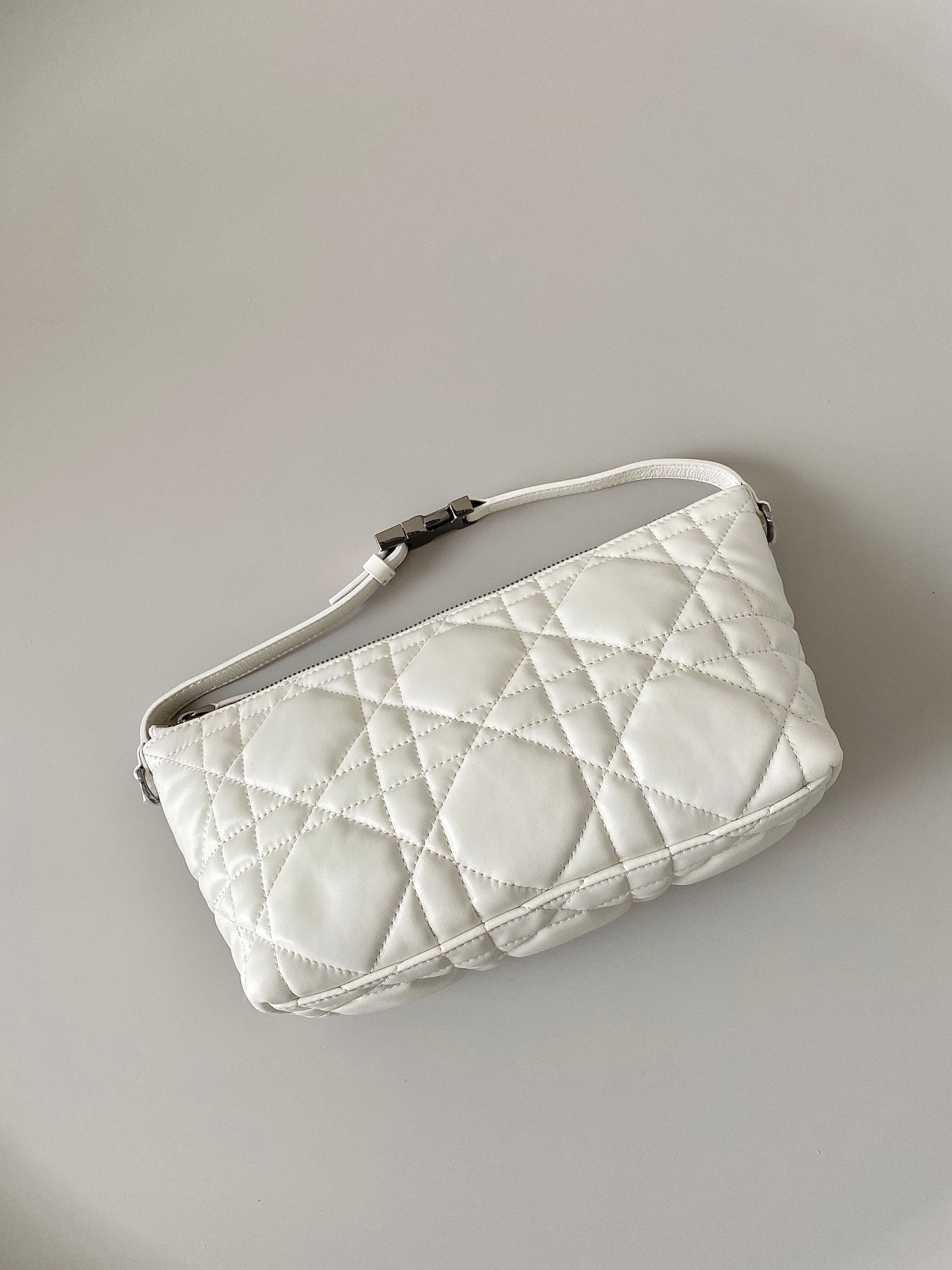 Small quilted white Dior bag with short strap and top zipper