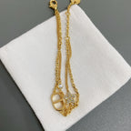 Dior gold-tone charm necklace with oval pendant and dangling round stones