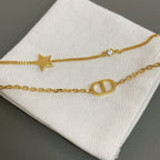 Dior gold-tone charm bracelet with star, oval letter charm, and small stones