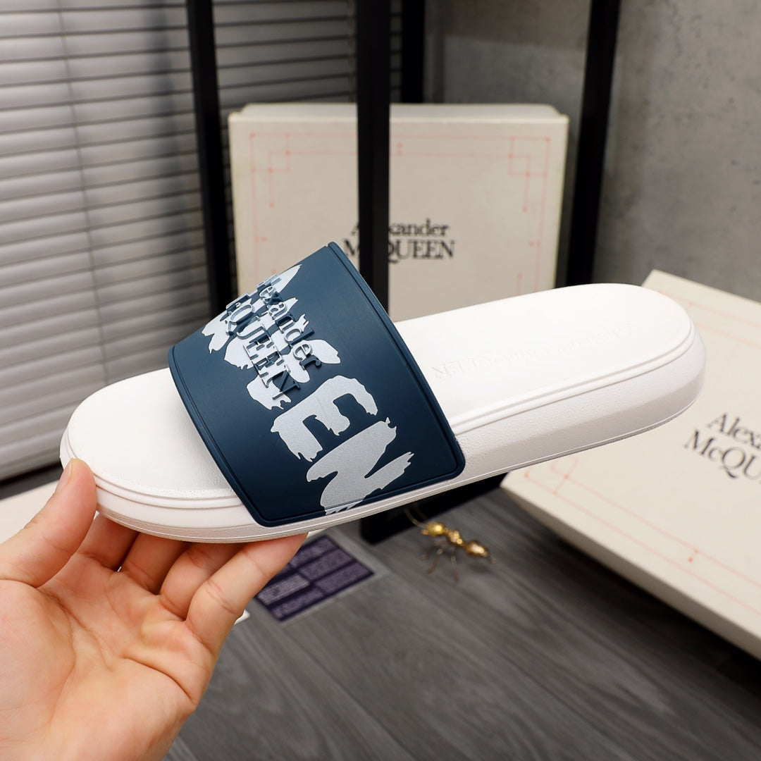 White slide sandal with navy strap and white logo graphic, angled view