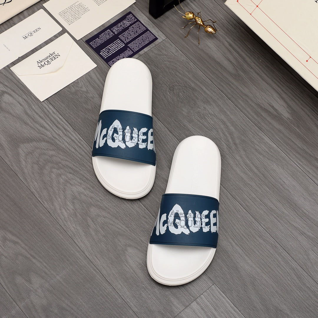 Pair of white slide sandals with navy logo strap and cushioned footbed