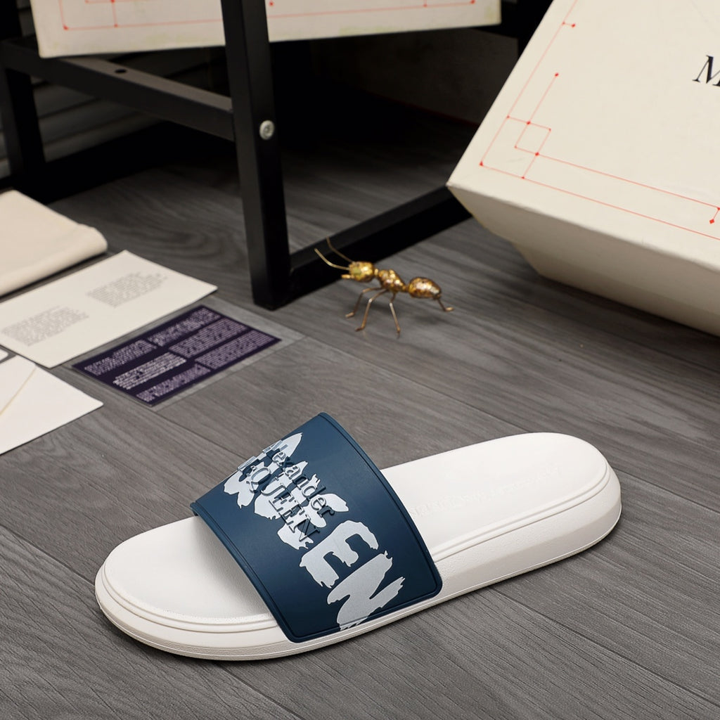 White slide sandal with navy strap and white graphic lettering, side view