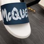 Navy strap on white slide sandal with white logo graphic, close-up
