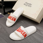 White Alexander McQueen slide sandals with red logo strap