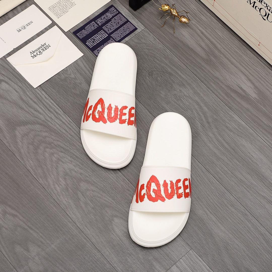 Pair of white slide sandals with red logo lettering on straps