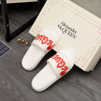 White slide sandals with red logo print on wide straps