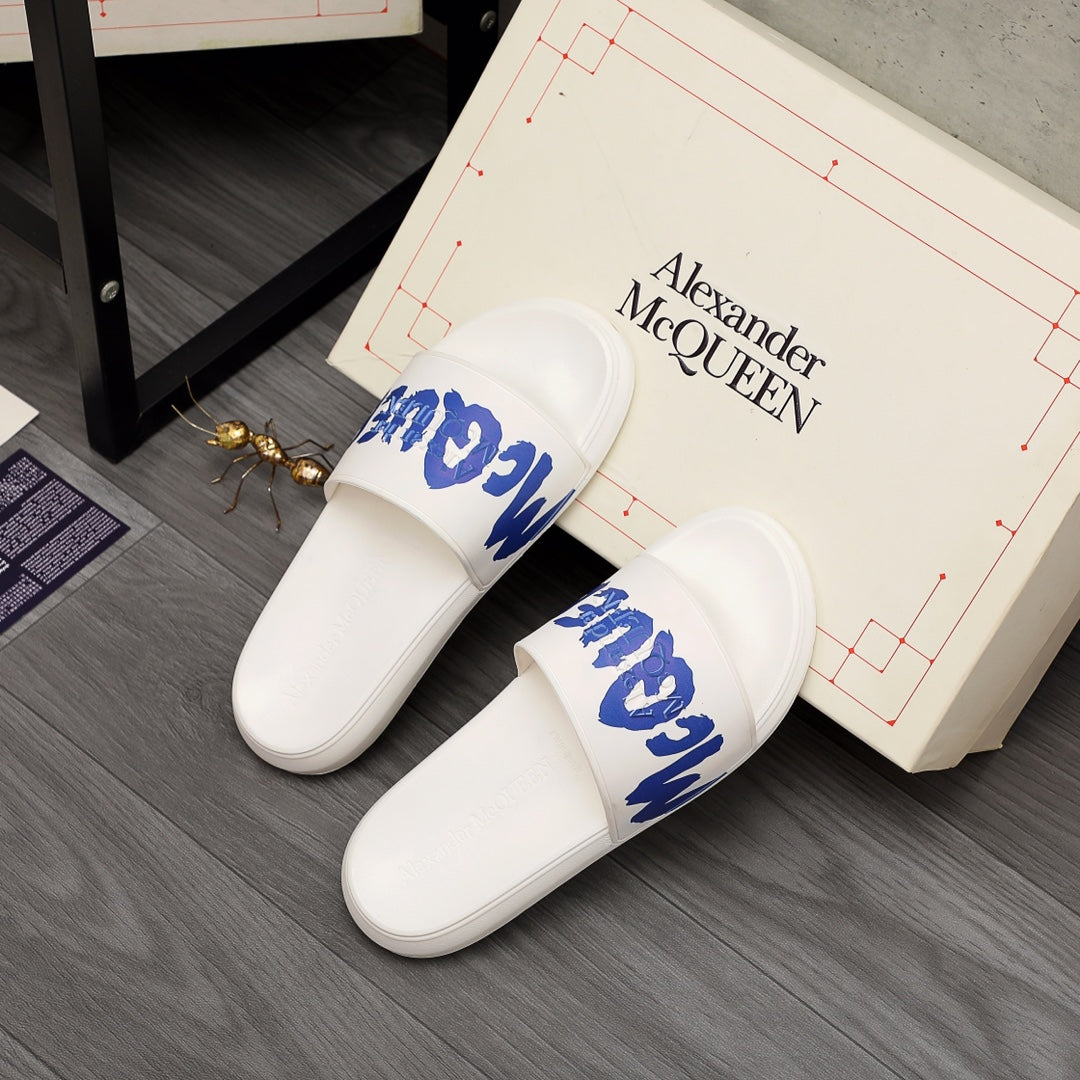 Alexander McQueen white slide sandals on box, blue logo straps visible