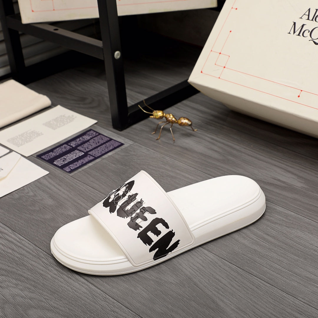 White slide sandals with black McQUEEN logo on the front strap