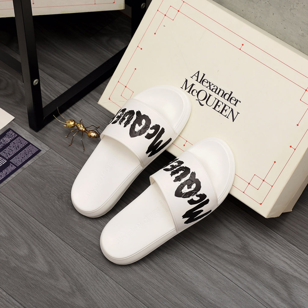 White slide sandals with black McQUEEN logo, side view