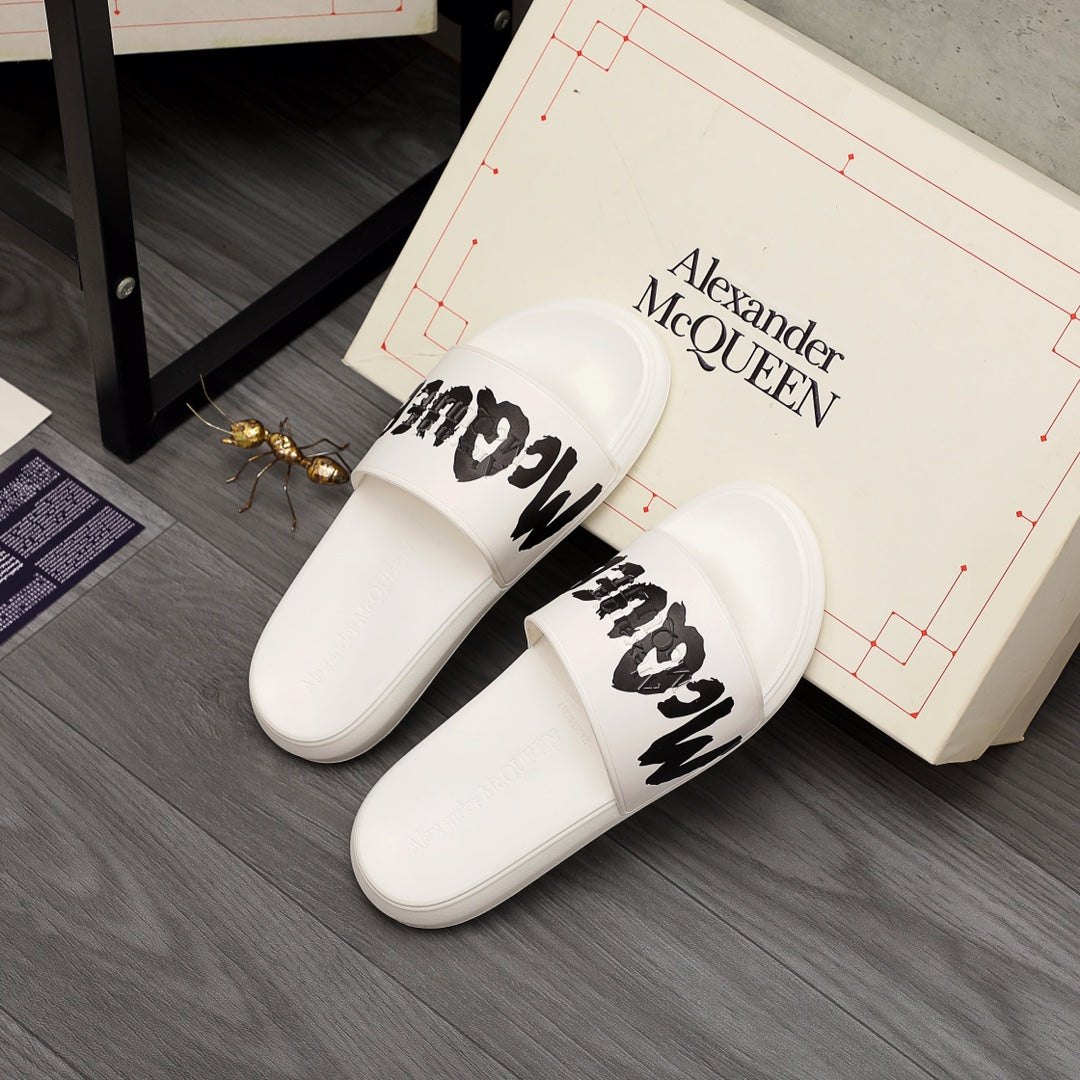White slide sandals with black McQUEEN logo, side view