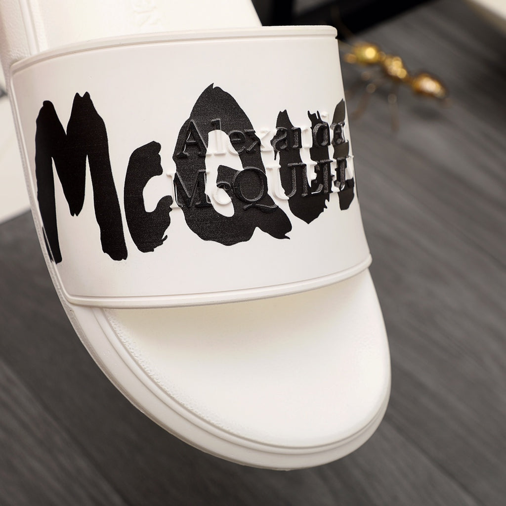 White slide sandal with oversized black McQUEEN graphic on strap
