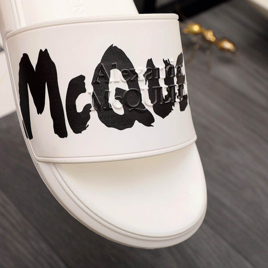 White slide sandal with oversized black McQUEEN graphic on strap