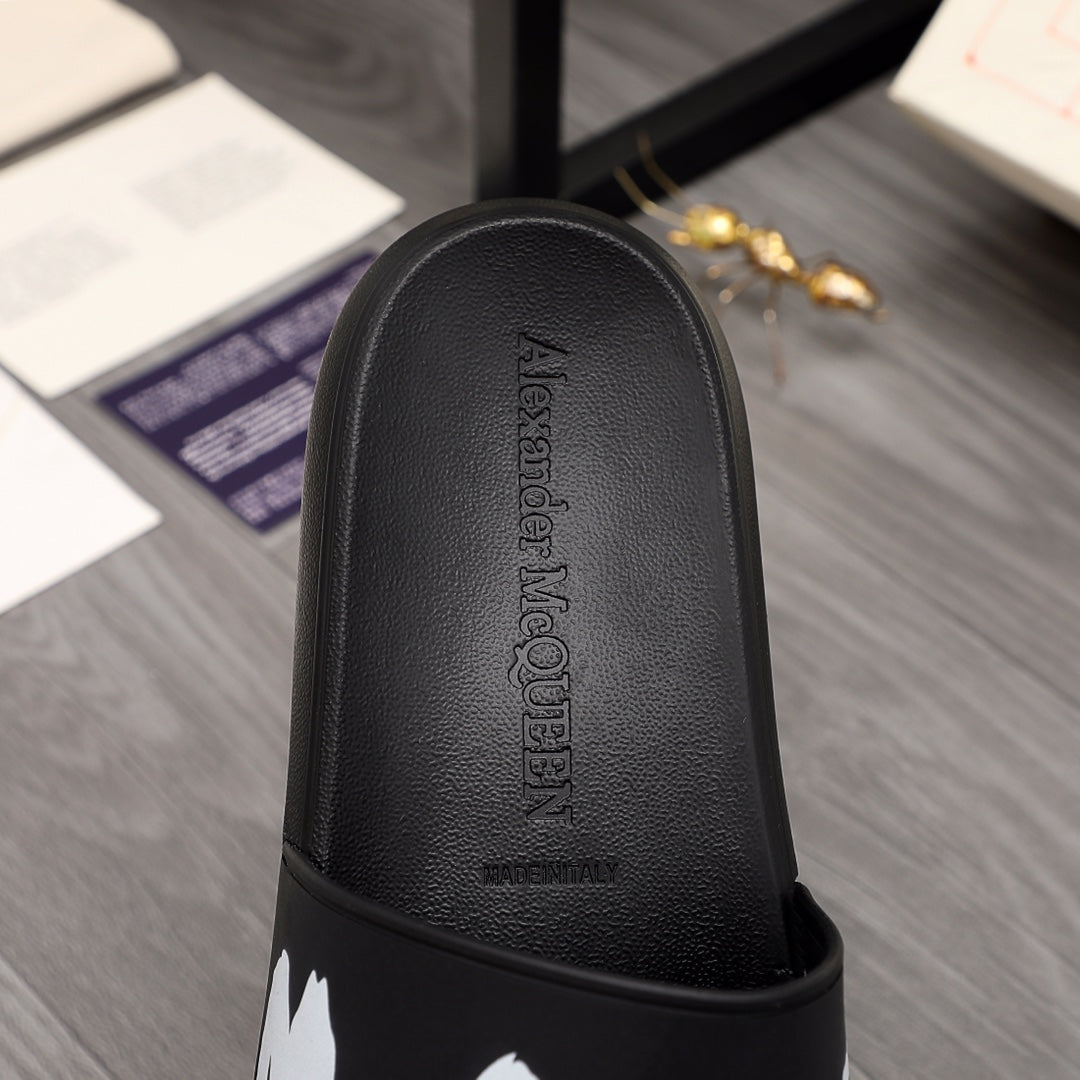 Black slide sandal footbed with textured leather look and raised logo detail.